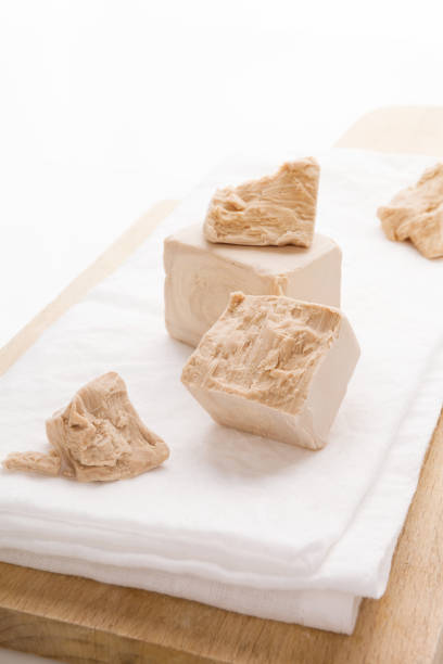 istock Fresh yeast blocks on wooden board. 1222055671