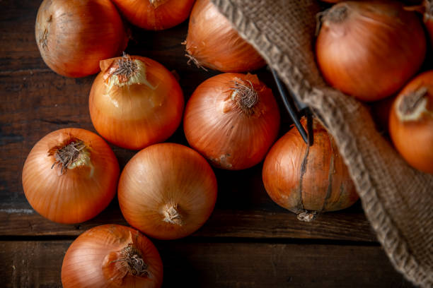 istock Fresh ripe onions on wood background. 1222055909