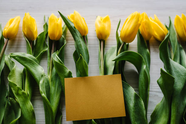 istock Craft postcard on yellow tulips on wooden background. Space for message. Concept Hello Spring flowers. Holiday greeting card for Valentine's, Women's, Mother's Day, Easter! Top view, flat lay. 1222057125