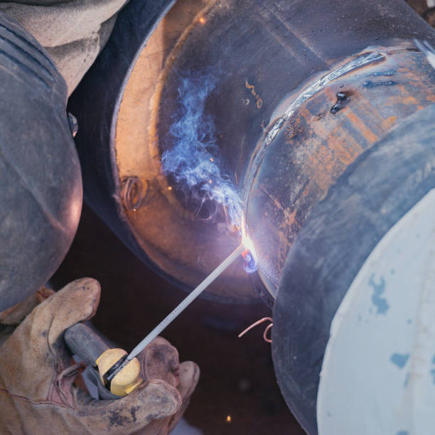 istock Welder worker welds new metal pipe. 1222057998