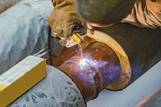 istock Welder worker welds new metal pipe. 1222058019