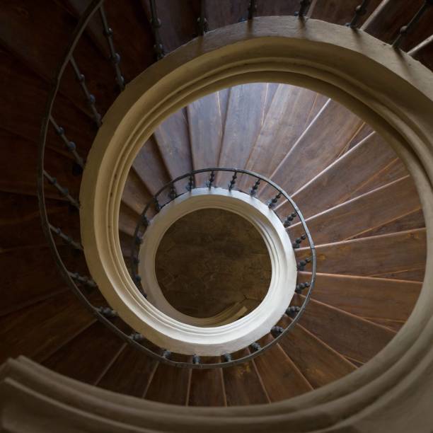istock Looking down an old empty wooden spiral staircase eith iron banister 1222062167
