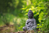 istock Buddha statue outside on nature and green background with copy space 1222066739