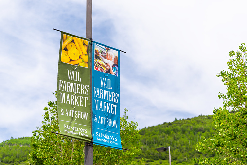 Vail, USA - June 29, 2019: Small ski resort Colorado town with sign for farmer's market in summer banner on lamp post