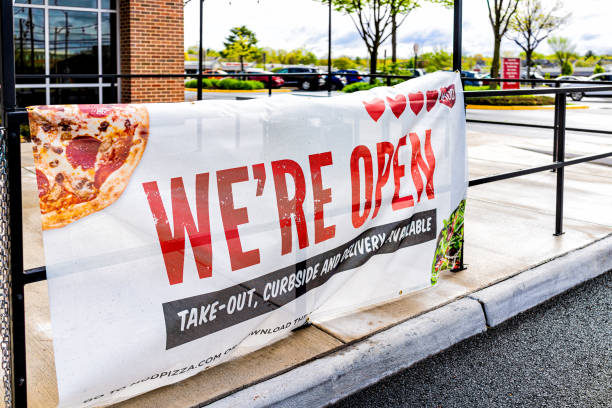 Sign for open pizza restaurant for take-out curbside and delivery during coronavirus Covid-19 epidemic Herndon, USA - April 27, 2020: Virginia Fairfax County street with sign for open pizza restaurant for take-out curbside and delivery during coronavirus Covid-19 epidemic mod stock pictures, royalty-free photos & images