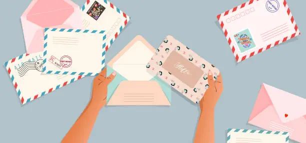 Vector illustration of Envelopes and post cards on the table. Hands holding an envelope. Top down view. Greeting card and a letter in a hand. Modern vector illustration for web design and print. Retro cards and envelopes.