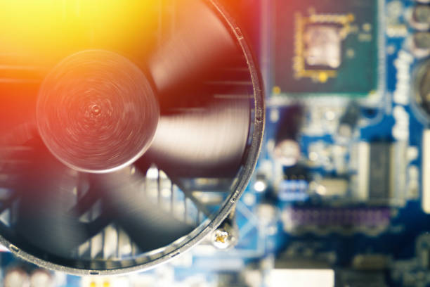 CPU cooler of processor on motherboard. Computer circuit board and CPU spinning cooling fans inside a PC for background. Toned photo