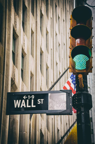 wall street assina close-up com semáforo verde vintage em manhattan, nova york e bandeira americana - wall street new york city street bank - fotografias e filmes do acervo