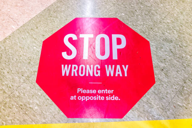 istock Red warning direction stop sign text for entering wrong way in store aisle during covid-19 coronavirus outbreak with nobody in USA 1222073639