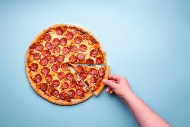 istock Grabbing a slice of pepperoni pizza top view. 1222073938