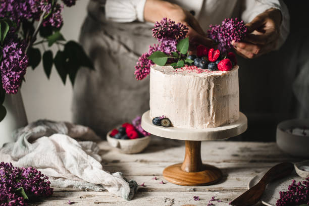 Female chef preparing fruit and flower cake
