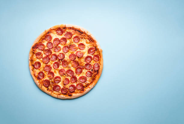 istock Pepperoni pizza top view on a blue background. 1222077663
