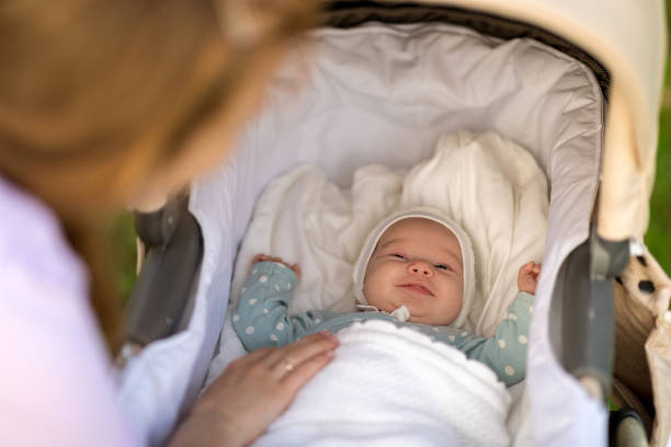 istock Newborn baby smiles lying in a stroller on a walk with mom 1222079443