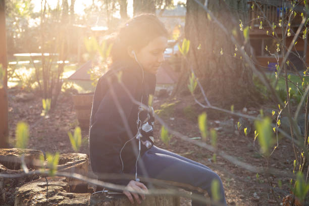 la ragazza ascolta la musica in giardino - children only tree area exploration freshness foto e immagini stock