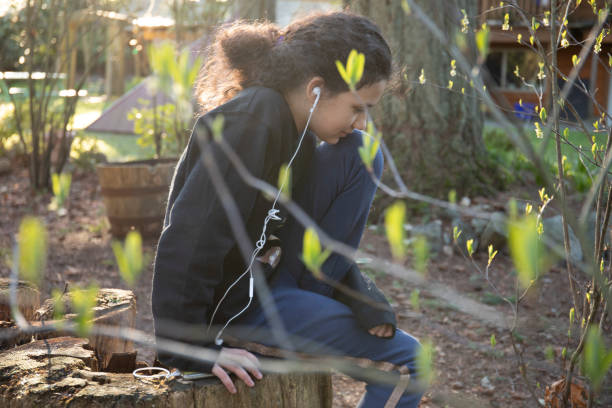 young girl listens to music in garden - children only tree area exploration freshness imagens e fotografias de stock