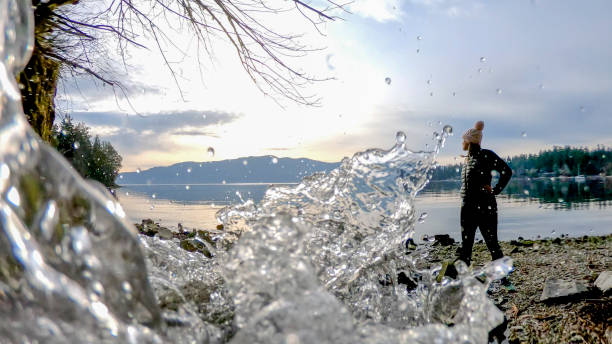 frau geht am strand entlang in der nähe des wasserstroms - nature zen like stream water stock-fotos und bilder