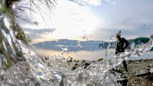 frau geht am strand entlang in der nähe des wasserstroms - nature zen like stream water stock-fotos und bilder