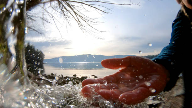 weibliche hand greift nach stromlauf des wassers - nature zen like stream water stock-fotos und bilder