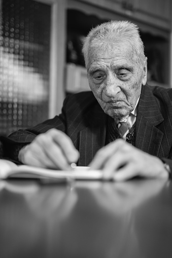 Senior Caucasian man writing diary or novel during lockdown.