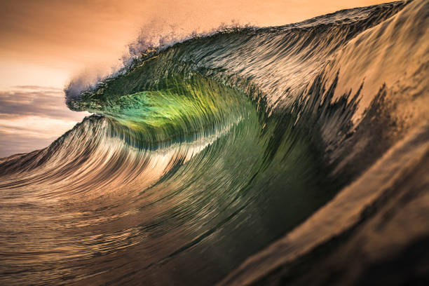 Golden lip of wave throwing in the ocean Golden lip of wave throwing in the ocean with burnt orange smoke filled sky khaki green photos stock pictures, royalty-free photos & images