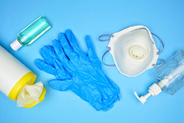 Coronavirus prevention equipment and sanitizer, top view set over blue Coronavirus prevention equipment, sanitizing wipes, hand sanitizer, gloves, n95 mask. Top view set on a blue background. prevention photos stock pictures, royalty-free photos & images