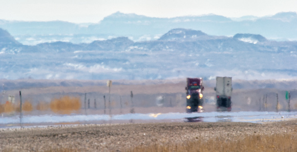 Heat Haze distorsiona el video de los semi-camiones que conducen por una carretera interestatal de Utah rodeada por las montañas en un día soleado photo