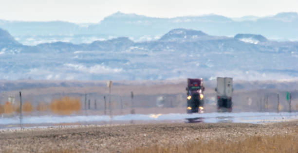 Heat Haze Distorts Video of Semi-Trucks Driving Down a Utah Interstate Surrounded by Mountains on a Sunny Day Heat Haze Distorts Video of Semi-Trucks Driving Down a Utah Interstate Surrounded by Mountains on a Sunny Day heat wave photos stock pictures, royalty-free photos & images