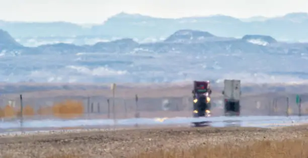 Photo of Heat Haze Distorts Video of Semi-Trucks Driving Down a Utah Interstate Surrounded by Mountains on a Sunny Day