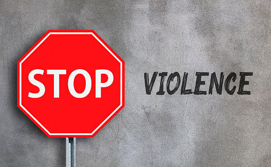 Stop violence with stop sign on wall background.