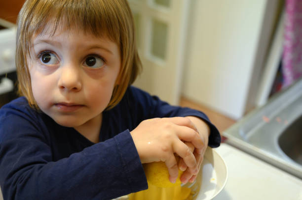istock Little girl squeezing lemon 1222086016