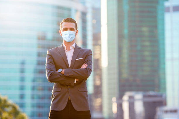 istock Businessman looking on copy space while standing against glass skyscraper 1222086504