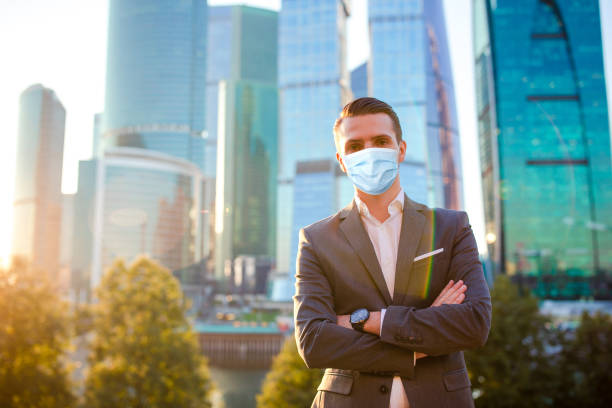 istock Businessman looking on copy space while standing against glass skyscraper 1222086556