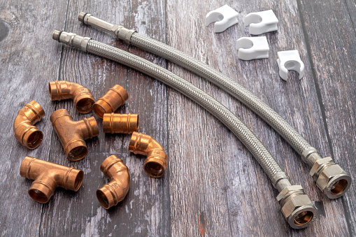 A plumbers copper tube background, with pipe clips and flexible tap connectors