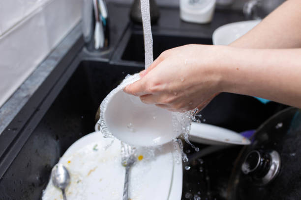 istock female hands wash dishes in the kitchen sink 1222087302