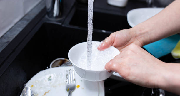 istock female hands wash dishes in the kitchen sink 1222087303