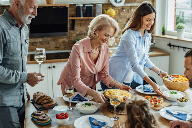 feliz familia multigeneración almorzando en casa. - adult offspring family multi generation family senior adult fotografías e imágenes de stock