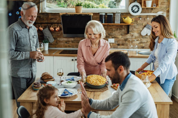 feliz familia multigeneracional almorzando juntos en el comedor - adult offspring family multi generation family senior adult fotografías e imágenes de stock