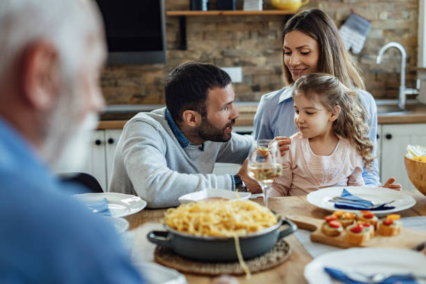 istock Young smiling family talking at dining table. 1222087792