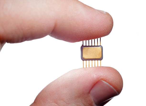 istock Electronic microchip with fingers close-up. Man hand holds microcircuit. 1222087886