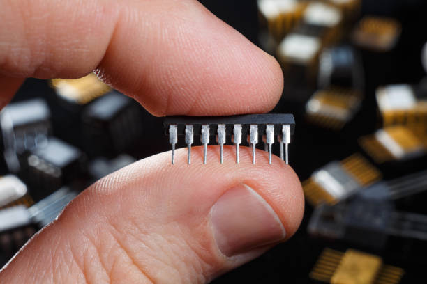 istock Electronic microcircuit with fingers close-up. Modern technology of electronic components. 1222087960