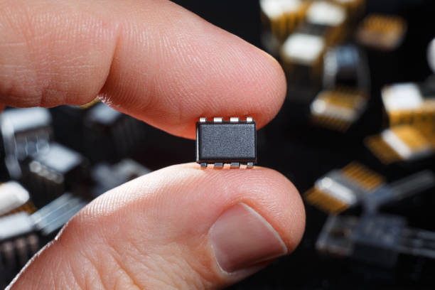 istock Electronic microchip with fingers close-up. Man hand holds microcircuit. 1222087963