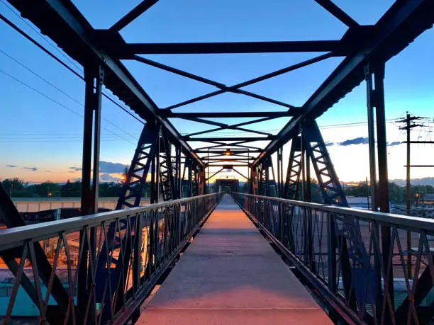 Point-Of-View Shot of Looking Down an Industrial, Steel Walking Bridge at Sunset/Sunrise