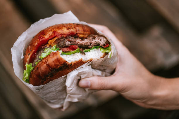 istock Hand holding a juicy burger 1222088902
