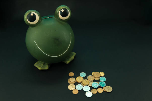 istock Piggy bank frog and coins. 1222090432