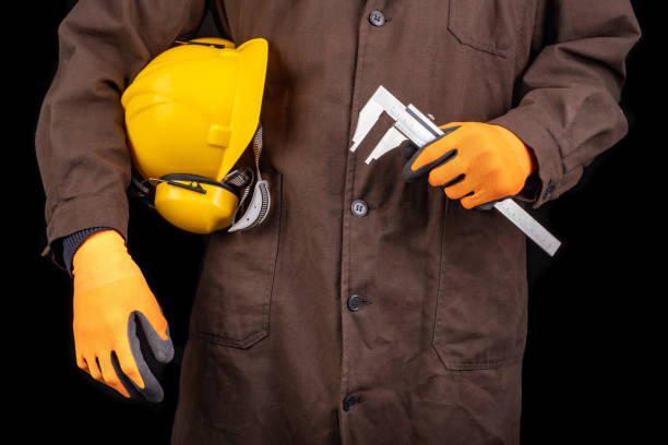 istock Production worker with helmet and caliper in hand. A man dressed in work clothes. Dark background. 1222090813