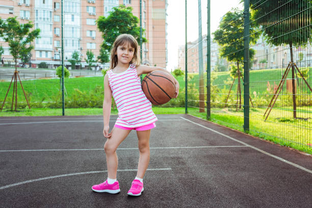 농구공을 가진 놀이터에 있는 소녀가 농구를 한다.  스포츠 라이프 스타일. - basketball teenager nature outdoors 뉴스 사진 이미지