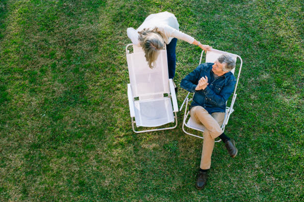 coppia anziana che si gode il giardino - couple affectionate relaxation high angle view foto e immagini stock