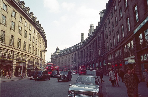 Regent Street, London, England, UK, 1970. Street scene with pedestrians, cars, taxis, buses, shops and impressive buildings on the famous Regent Street.