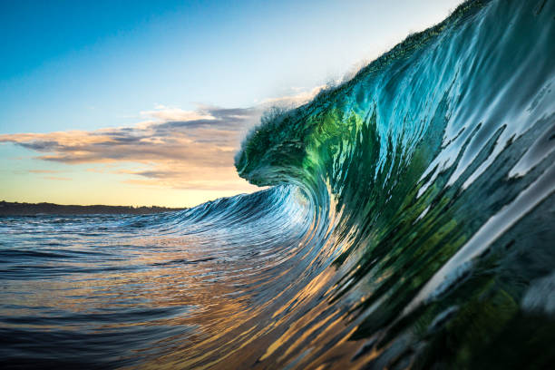 bunte welle bricht im ozean über riff und felsen - surfen fotos stock-fotos und bilder