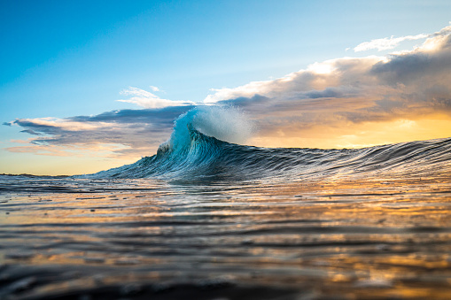 Colorida ola alcanzando un pico en una llamarada con tormenta al amanecer photo